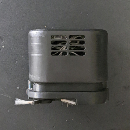 mini desk vacuum side view side view, picos just visible and there are a couple wires next to the vent